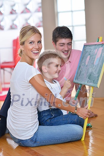 happy young family teach leassons and prepare their son for school while draw on board at home happy young family teach leassons and prepare their son for school while draw on board at home