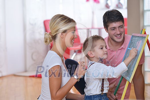 happy young family teach leassons and prepare their son for school while draw on board at home happy young family teach leassons and prepare their son for school while draw on board at home