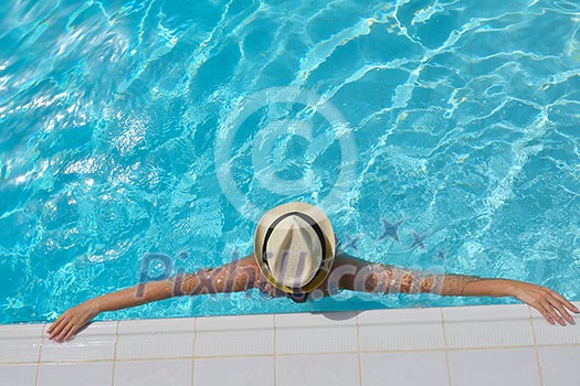 Happy smiling woman with hat and sunglasses in swimming pool at tropical resort Happy smiling woman with hat and sunglasses in swimming pool at tropical resort