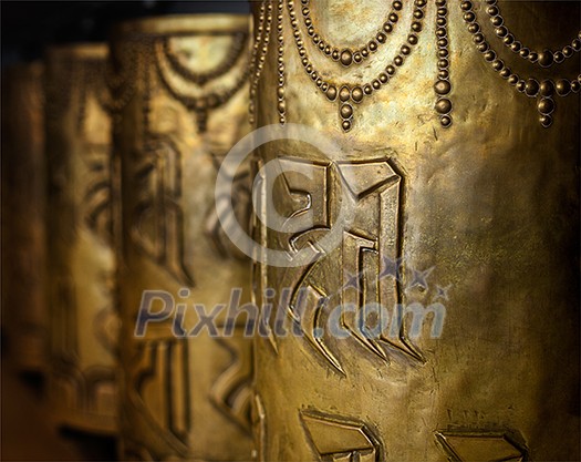 Tibetan Buddhist prayer wheels in Buddhism temple. Shallow depth of field. McLeod Ganj, HImachal Pradesh, India Tibetan Buddhist prayer wheels in Buddhism temple. Shallow depth of field. McLeod Ganj, HImachal Pradesh, India