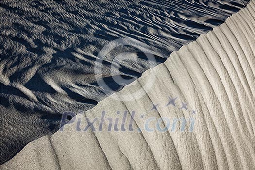 Shadow and light on Nubra Valley dunes sand close up on sunrise. Ladakh, India Shadow and light on Nubra Valley dunes sand close up on sunrise. Ladakh, India