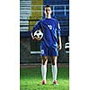 portrait of young handsome soccer player man at football stadium and green grass