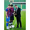 soccer  sport manager in business suit coach and football player on stadium with green grass and white ball