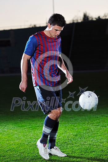 soccer player doing kick with ball on football stadium field isolated on black background in night soccer player doing kick with ball on football stadium field isolated on black background in night