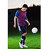 soccer player doing kick with ball on football stadium  field  isolated on black background  in night