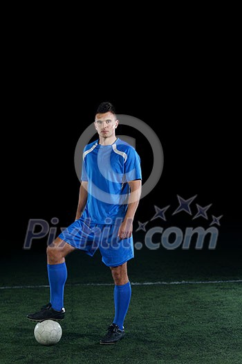 soccer player doing kick with ball on football stadium field isolated on black background soccer player doing kick with ball on football stadium field isolated on black background