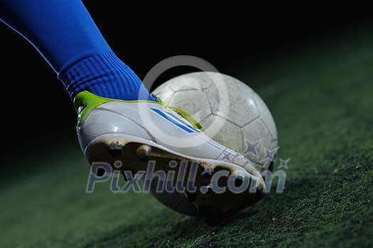 soccer player doing kick with ball on football stadium field isolated on black background soccer player doing kick with ball on football stadium field isolated on black background