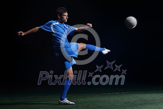 soccer player doing kick with ball on football stadium field isolated on black background soccer player doing kick with ball on football stadium field isolated on black background