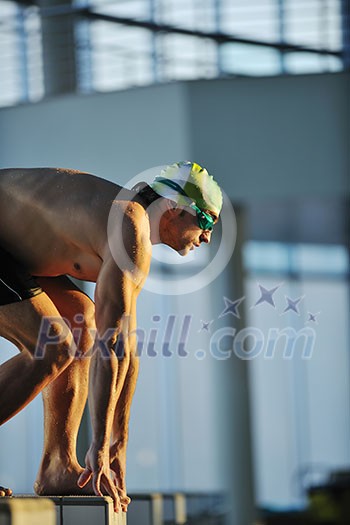 start position race concept with fit swimmer on swimming pool start position race concept with fit swimmer on swimming pool
