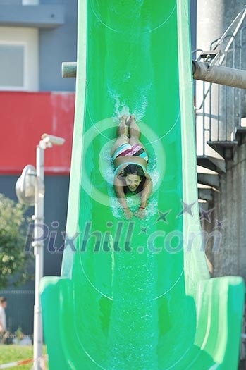 happy girl have fun on water slide at outdoor swimming pool happy girl have fun on water slide at outdoor swimming pool