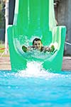 happy girl have fun  on water slide at outdoor swimming pool