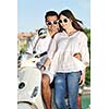 Portrait of happy young love couple on scooter enjoying themselves in a park at summer time