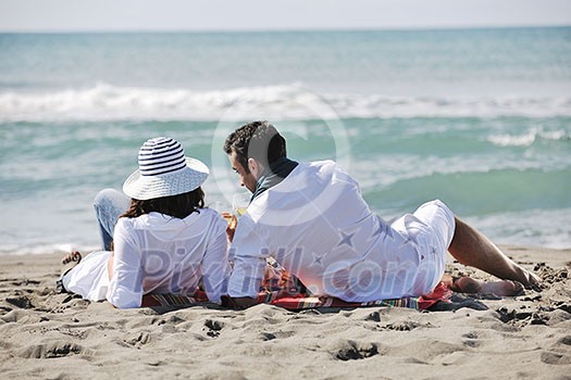 happy young couple enjoying picnic on the beach and have good time on summer vacations happy young couple enjoying picnic on the beach and have good time on summer vacations