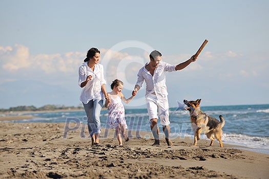 happy young family in white clothing have fun and play with beautiful dog at vacations on beautiful beach happy young family in white clothing have fun and play with beautiful dog at vacations on beautiful beach