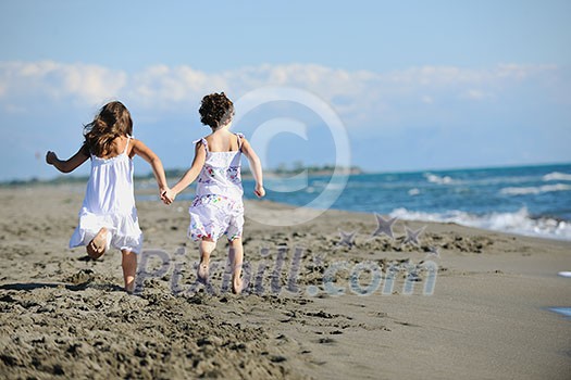 happy two little girls have fun and joy time at beautiful beach while running from joy happy two little girls have fun and joy time at beautiful beach while running from joy