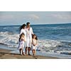 happy young family in white clothing have fun at vacations on beautiful beach 