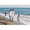 happy young family in white clothing have fun at vacations on beautiful beach