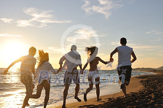 happy young friends group have fun and celebrate while jumping and running on the beach at the sunset happy young friends group have fun and celebrate while jumping and running on the beach at the sunset