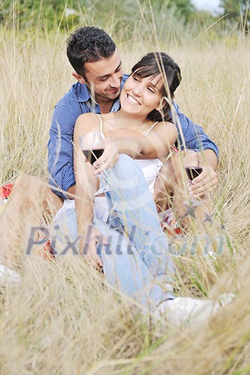 happy young couple enjoying  picnic on the countryside in the field  and have good time