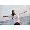 happy young woman relax on beautiful  beach at fresh summer morning and enjoy first ray of sun