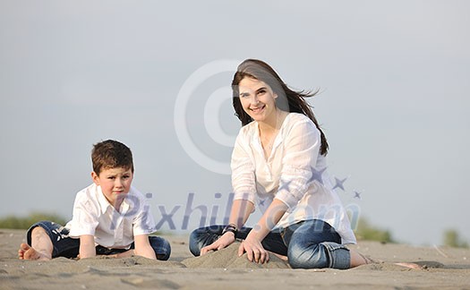 happy young mother and son relaxing and play ind sand games on beach at summer season happy young mother and son relaxing and play ind sand games on beach at summer season