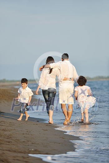 happy young family have fun on beach run and jump at sunset happy young family have fun on beach run and jump at sunset