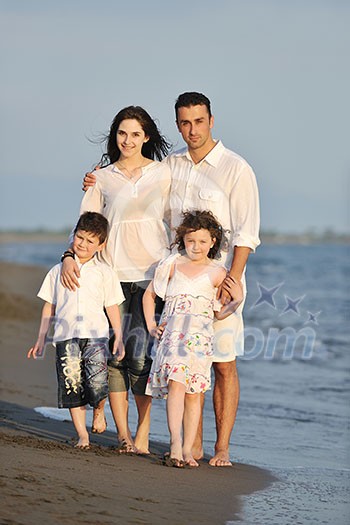 happy young family have fun on beach run and jump at sunset happy young family have fun on beach run and jump at sunset