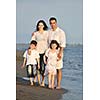 happy young family have fun on beach run and jump  at sunset