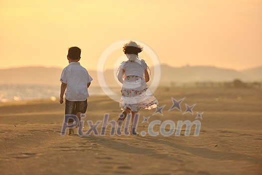 happy young family have fun on beach run and jump at sunset happy young family have fun on beach run and jump at sunset
