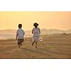 happy young family have fun on beach run and jump  at sunset