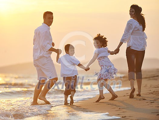 happy young family have fun on beach run and jump at sunset happy young family have fun on beach run and jump at sunset