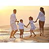 happy young family have fun on beach run and jump  at sunset