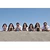 Group of happy young people in circle at beach have fun