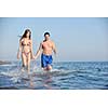 happy young couple have romantic time on beach at sunset
