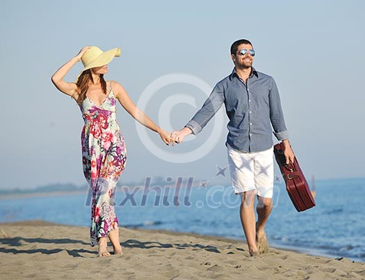 couple on beach with travel bag representing freedom and funy honeymoon concept couple on beach with travel bag representing freedom and funy honeymoon concept