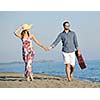 couple on beach with travel bag representing freedom and funy honeymoon concept