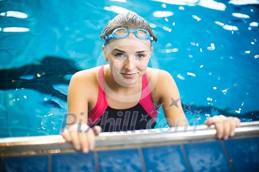 Female swimmer in an indoor swimming pool - doing crawl (shallow DOF) Female swimmer in an indoor swimming pool - doing crawl (shallow DOF)