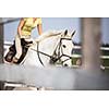 Young woman show jumping with horse