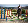 Young woman show jumping with horse