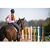 Young woman show jumping with horse