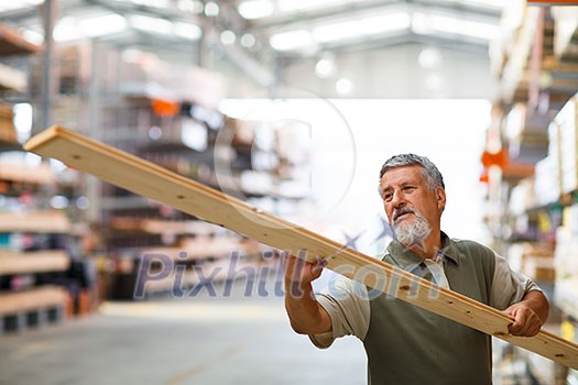 Man choosing and buying construction wood in a DIY store for his DIY home re-modeling project Man choosing and buying construction wood in a DIY store for his DIY home re-modeling project