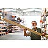 Man choosing and buying construction wood in a  DIY store for his DIY home re-modeling project