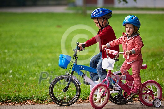 happy kids in park, boy and girl in nature with bicycle have fun happy kids in park, boy and girl in nature with bicycle have fun