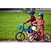 happy kids in park, boy and girl in nature with bicycle have fun