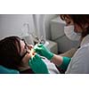 Closeup of a woman patient at the dentist waiting to be checked up with the woman doctor in the background