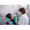 Closeup of a woman patient at the dentist waiting to be checked up with the woman doctor in the background