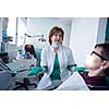 Closeup of a woman patient at the dentist waiting to be checked up with the woman doctor in the background