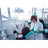Closeup of a woman patient at the dentist waiting to be checked up with the woman doctor in the background
