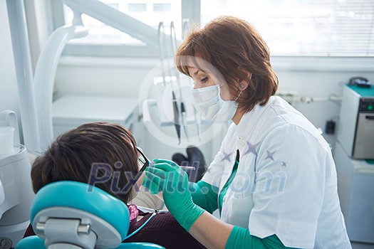 Closeup of a woman patient at the dentist waiting to be checked up with the woman doctor in the background Closeup of a woman patient at the dentist waiting to be checked up with the woman doctor in the background