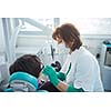 Closeup of a woman patient at the dentist waiting to be checked up with the woman doctor in the background